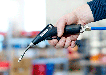 SILVENT Pro One air blow gun held by a hand in a factory, directed downward for use.